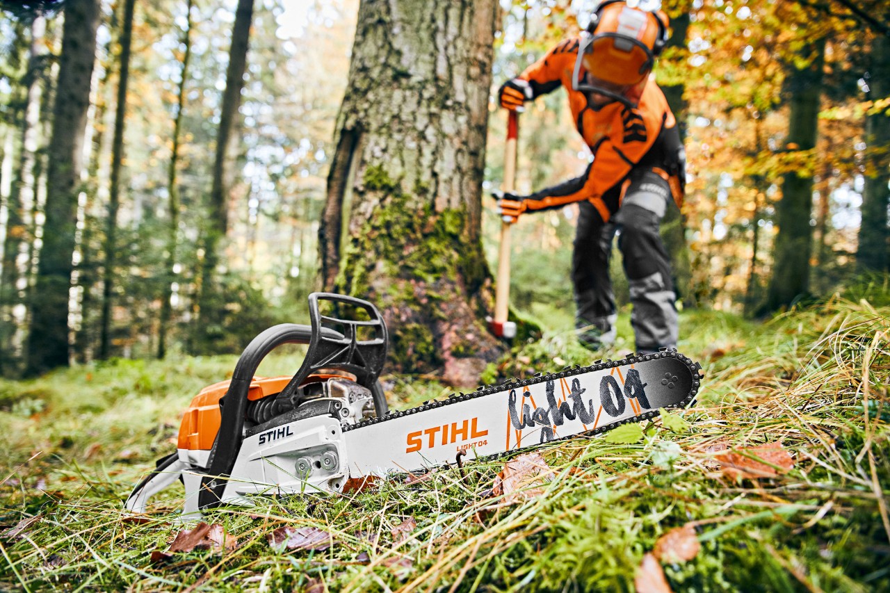 Hombre con equipo de protección en el bosque, en primer plano Motosierra de gasolina STIHL MS 261 CM con espada Light 04