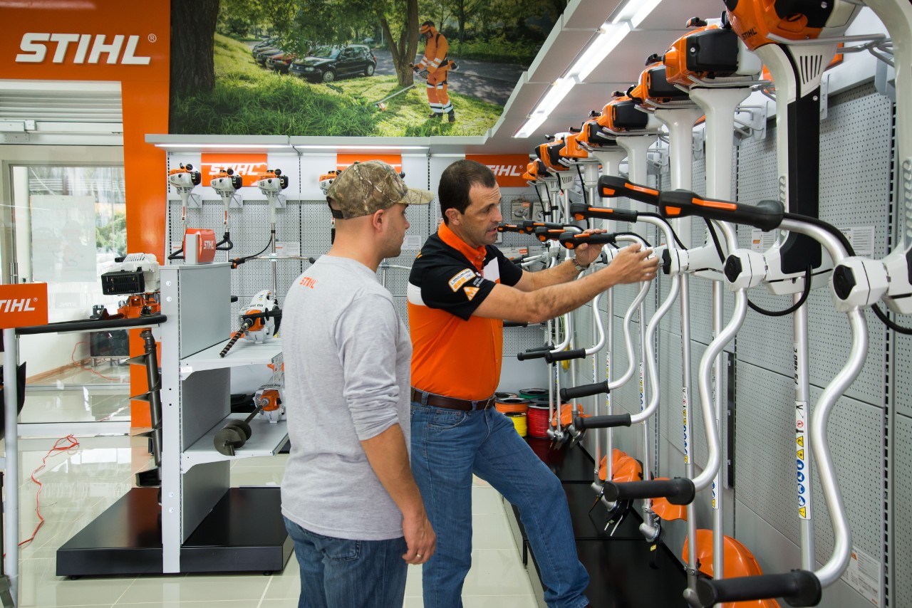 Un distribuidor STIHL aconseja a un hombre joven durante la compra