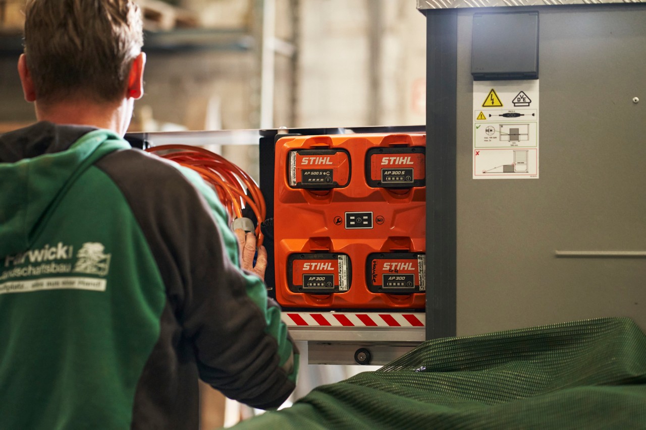Un empleado de Farwick GmbH, visto desde atrás, se encuentra frente a un bottTainer impulsado por STIHL.
