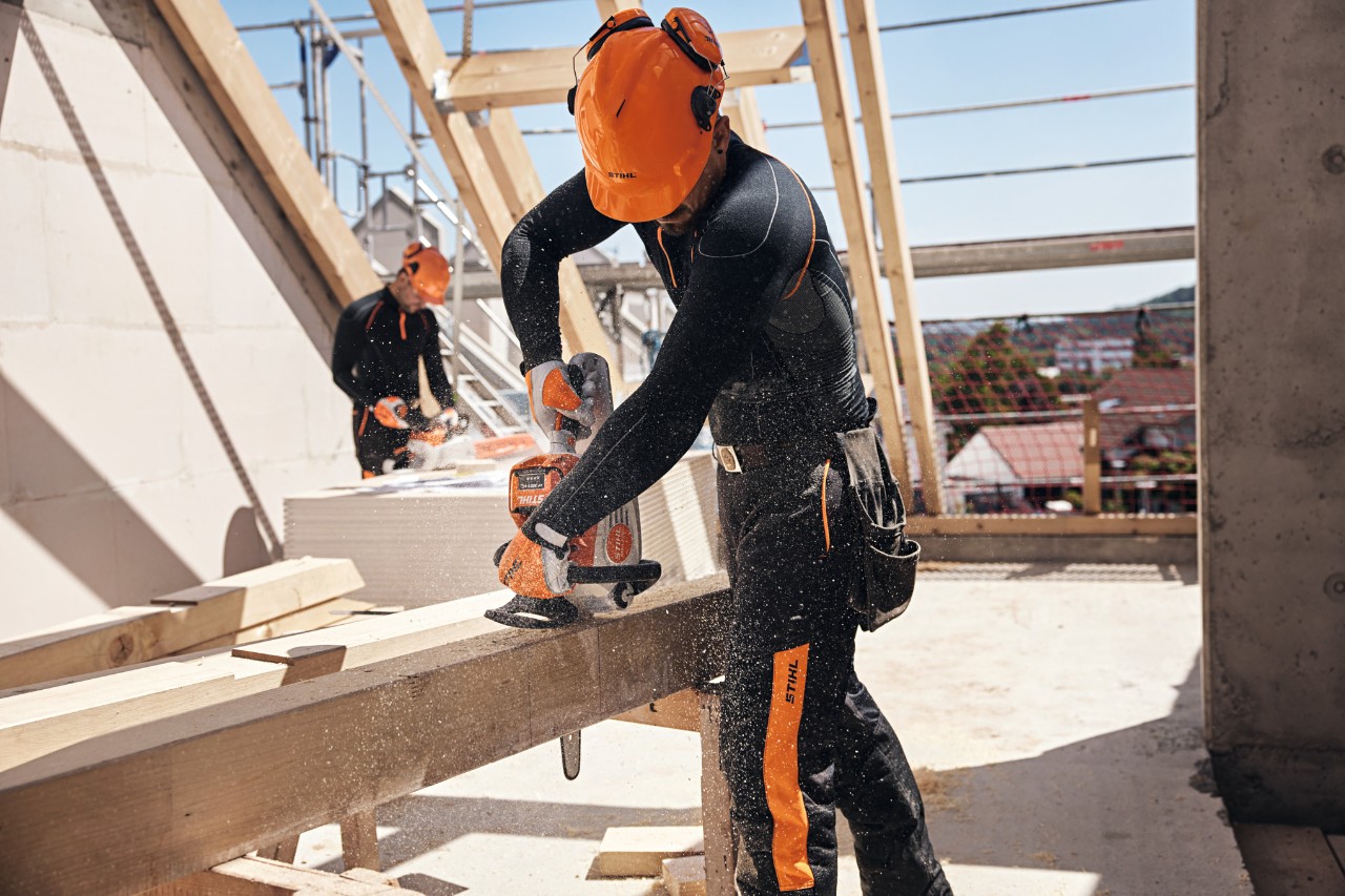 Un grupo de paisajistas y jardineros utilizan máquinas de batería STIHL AP y una batería de mochila de la plataforma de carga del vehículo. 